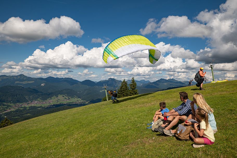 Familie beobachtet Paragleiter beim Start